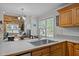 Bright kitchen with a stainless steel sink, wood cabinets, and a view of the home's living room at 545 Olivia Way, Selma, NC 27576