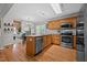 Modern kitchen with wood cabinets, island, stainless steel appliances, open to a cozy living space at 545 Olivia Way, Selma, NC 27576