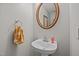 This half bathroom offers a pedestal sink and a decorative round mirror at 545 Olivia Way, Selma, NC 27576