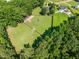 Aerial view of large acreage featuring horse property surrounded by lush green trees at 545 Olivia Way, Selma, NC 27576