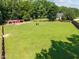 Aerial view of pasture featuring horse barns, fenced in pastures, and lush mature trees at 545 Olivia Way, Selma, NC 27576
