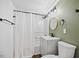 Updated bathroom with green walls, shower, and white vanity at 606 E Club Blvd, Durham, NC 27704