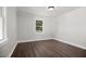 This neutral bedroom features recently installed wood-look flooring and a large window at 606 E Club Blvd, Durham, NC 27704