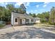 Charming white home with a cozy front porch and well-maintained gravel yard surrounded by mature trees at 606 E Club Blvd, Durham, NC 27704