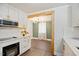 Modern kitchen with white cabinets, hardwood floors, stainless steel appliances, and view into dining area at 606 E Club Blvd, Durham, NC 27704