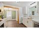 Modern white kitchen with stainless steel appliances, quartz countertops, and view into adjacent dining area at 606 E Club Blvd, Durham, NC 27704