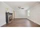 Bright living room with a decorative fireplace, crown molding, ceiling fan, and hardwood floors at 606 E Club Blvd, Durham, NC 27704