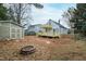 Landscaped backyard featuring a new two-story deck, shed, and fire pit at 625 New Road Rd, Raleigh, NC 27608