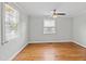 Bright bedroom features hardwood floors, neutral walls, ceiling fan, and natural light from the windows at 625 New Road Rd, Raleigh, NC 27608