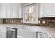 Bright kitchen featuring a brick backsplash, white cabinetry and marble counters at 625 New Road Rd, Raleigh, NC 27608