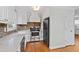 Bright kitchen featuring a brick backsplash, stainless steel appliances, and white cabinetry at 625 New Road Rd, Raleigh, NC 27608