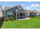 Well-manicured backyard with a grassy lawn and a screened porch on a home with gray siding at 705 Churton Pl, Cary, NC 27518