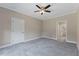 This bedroom features neutral walls, plush carpet, ceiling fan, and white doors at 705 Churton Pl, Cary, NC 27518