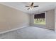 This bedroom boasts neutral walls, plush carpet, ceiling fan, and a window with a view at 705 Churton Pl, Cary, NC 27518