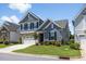 Charming two-story home with a stone accent, a two-car garage and manicured landscaping at 705 Churton Pl, Cary, NC 27518