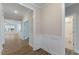 Bright hallway with wood floors that leads to living spaces and a bathroom at 705 Churton Pl, Cary, NC 27518