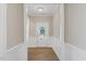 Inviting hallway with wood floors, white wainscoting, and a view of the front door at 705 Churton Pl, Cary, NC 27518