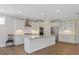 Bright kitchen boasts stainless appliances, a large island, and white cabinetry and countertops at 705 Churton Pl, Cary, NC 27518