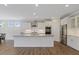 Bright kitchen features stainless appliances, large island with sink, and white cabinetry at 705 Churton Pl, Cary, NC 27518