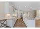 Bright kitchen features stainless appliances, a large island, and white cabinetry and countertops at 705 Churton Pl, Cary, NC 27518