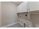Compact laundry room featuring white cabinetry and tile flooring at 705 Churton Pl, Cary, NC 27518