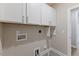Compact laundry room featuring white cabinetry and tile flooring at 705 Churton Pl, Cary, NC 27518
