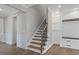 Welcoming foyer with elegant staircase featuring wood treads and black iron balusters, complemented by wainscoting details at 705 Churton Pl, Cary, NC 27518