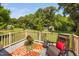 Back deck with outdoor seating, beautiful flower arrangement, and a view of a grassy backyard with mature trees at 73 Richmond Dr, Archer Lodge, NC 27527