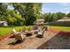 Inviting backyard patio featuring comfortable seating, a fire pit, and a charming covered bar area for outdoor entertaining at 73 Richmond Dr, Archer Lodge, NC 27527