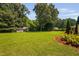 Spacious backyard with mature trees, a well-maintained lawn, and an outbuilding for storage or hobbies at 73 Richmond Dr, Archer Lodge, NC 27527