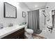 Bathroom featuring a single sink vanity, toilet, and tub with grey chevron curtain at 73 Richmond Dr, Archer Lodge, NC 27527