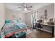 Cozy bedroom with ceiling fan, a bed with colorful bedding, a work desk, and wood-look flooring at 73 Richmond Dr, Archer Lodge, NC 27527
