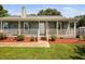 Charming home featuring a cozy front porch with flowers, a welcoming entrance, and a green lawn at 73 Richmond Dr, Archer Lodge, NC 27527
