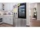 View of kitchen with stainless steel refrigerator, white cabinetry, and view to living area at 73 Richmond Dr, Archer Lodge, NC 27527