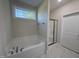 Relaxing bathroom with soaking tub under window, marble tile, and a glass-enclosed shower at 78 Mineral Springs Way, Benson, NC 27504