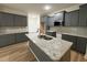 Kitchen with an island featuring granite countertops and gray cabinets at 78 Mineral Springs Way, Benson, NC 27504