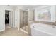 Bathroom featuring tiled shower, soaking tub, and view of walk-in closet for spa-like feel at 78 N Porcenna Ln, Clayton, NC 27527