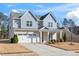 Two-story home boasts a two-car garage, covered porch, and manicured landscaping at 78 N Porcenna Ln, Clayton, NC 27527