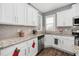 Corner view of kitchen features stainless steel appliances, granite countertops, and white cabinetry at 78 N Porcenna Ln, Clayton, NC 27527
