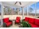 Relaxing sunroom with cozy red furniture, screened windows, and a view of the outdoors at 78 N Porcenna Ln, Clayton, NC 27527