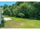 Grassy backyard featuring lots of green trees, well maintained lawn, and patio space at 7807 Braefield Dr, Raleigh, NC 27616