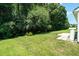 Well-maintained backyard features a large grassy area, patio, and lush green trees at 7807 Braefield Dr, Raleigh, NC 27616