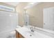 Bathroom with mirror, sink, toilet and shower with white tiling and cream walls at 7807 Braefield Dr, Raleigh, NC 27616