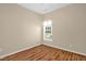 Neutral bedroom with wood flooring, featuring a bright window and modern lighting at 7807 Braefield Dr, Raleigh, NC 27616