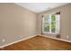 Cozy bedroom with neutral walls, wood floor and a bright window with sheer curtains at 7807 Braefield Dr, Raleigh, NC 27616