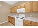 The kitchen includes a white range and microwave with light wood cabinets and countertops at 7807 Braefield Dr, Raleigh, NC 27616