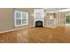 Spacious living room featuring a fireplace, large windows, and wood laminate flooring at 7807 Braefield Dr, Raleigh, NC 27616