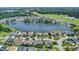Aerial view of a suburban neighborhood with a large pond in the distance with multiple houses and trees at 8007 Crookneck Dr, Angier, NC 27501