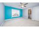 Bright bedroom with blue accent wall, a window, and access to an en-suite bathroom at 8007 Crookneck Dr, Angier, NC 27501