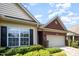 Charming brick home featuring a two-car garage, manicured lawn, and beautiful landscaping at 8007 Crookneck Dr, Angier, NC 27501